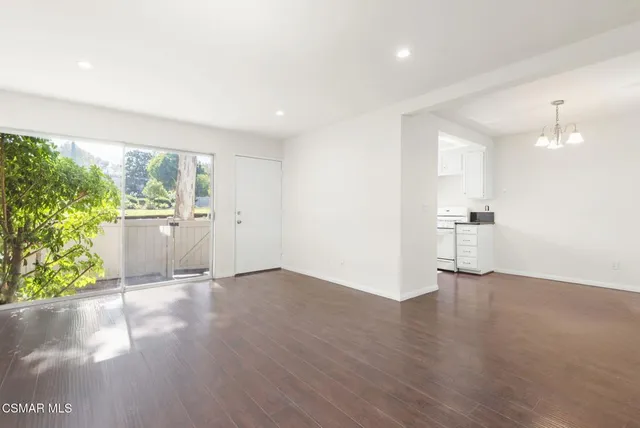 a view of a kitchen with wooden floor and a window