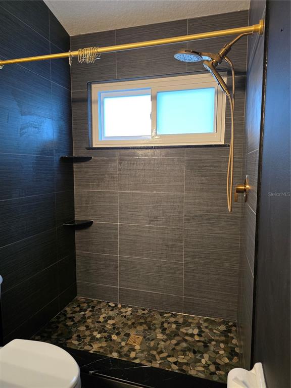 11229 Kapok Grand Circle Madeira Beach, FL 33708 - Photo 13 of 23 a bathroom with a toilet and a shower