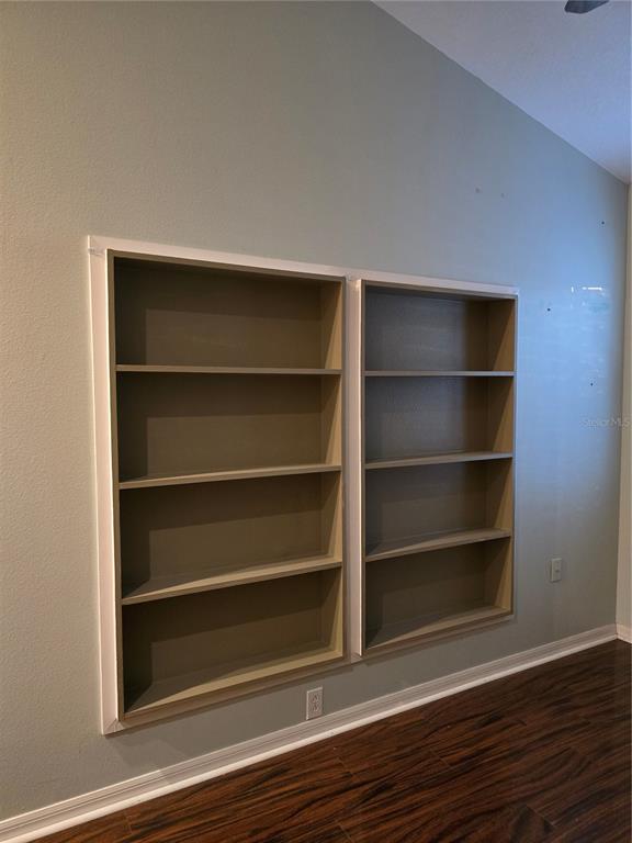 11229 Kapok Grand Circle Madeira Beach, FL 33708 - Photo 10 of 23 a room with a wooden floor and shelf