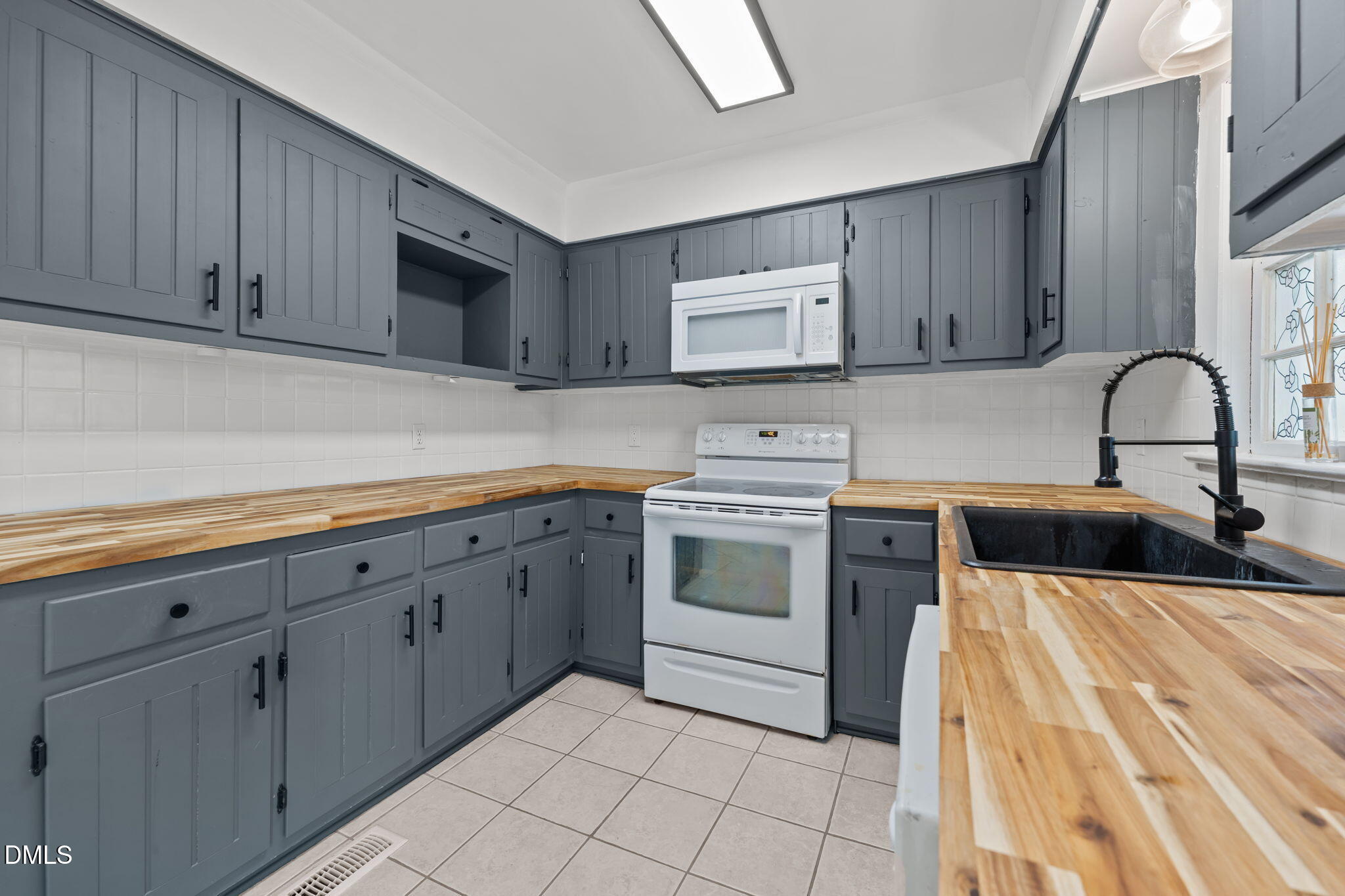 8718 Moody Road Liberty, NC 27298 - Photo 11 of 52 a kitchen with sink a stove and cabinets