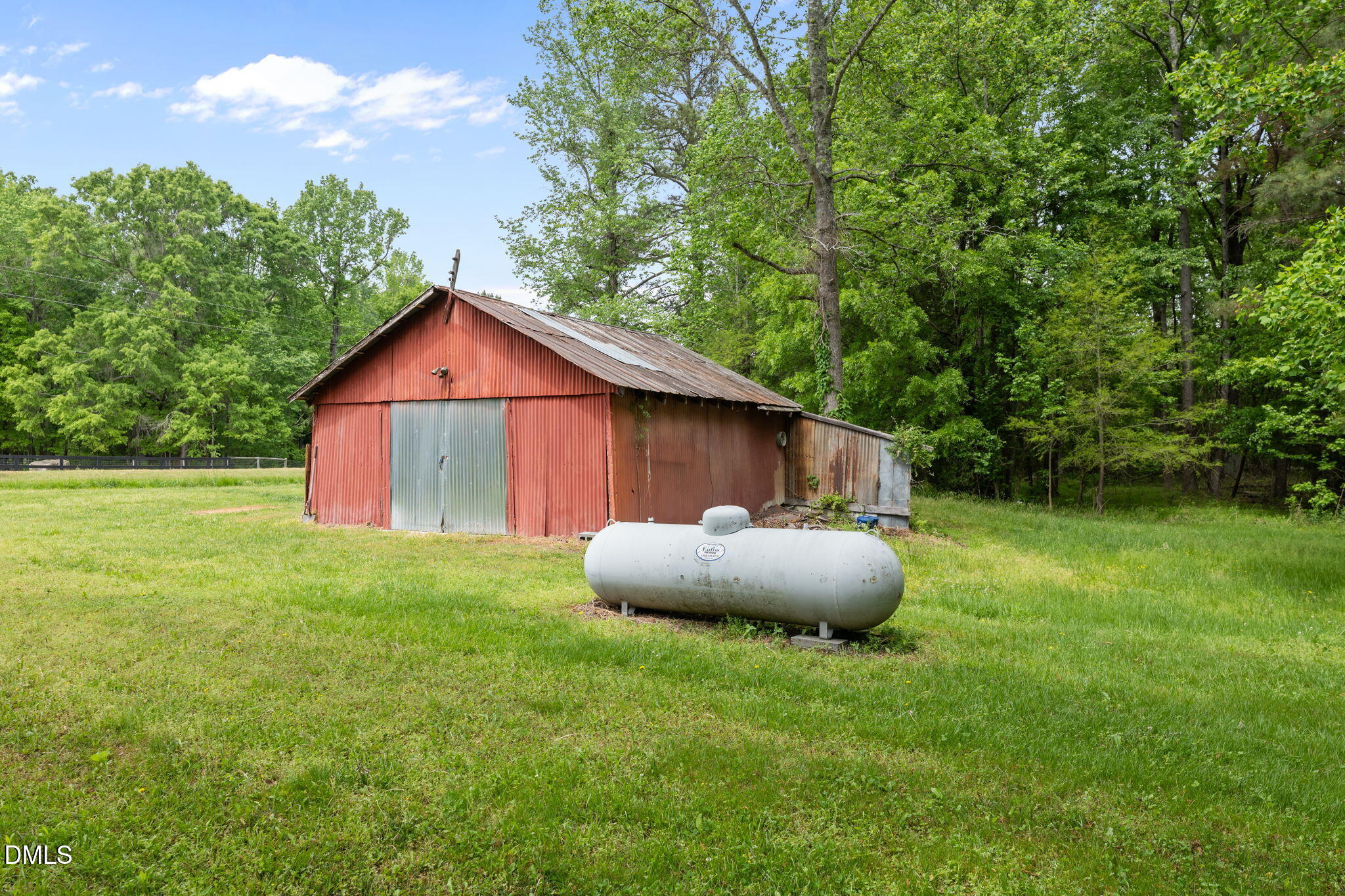 8718 Moody Road Liberty, NC 27298 - Photo 37 of 52 a backyard of a house with table and chairs under an umbrella