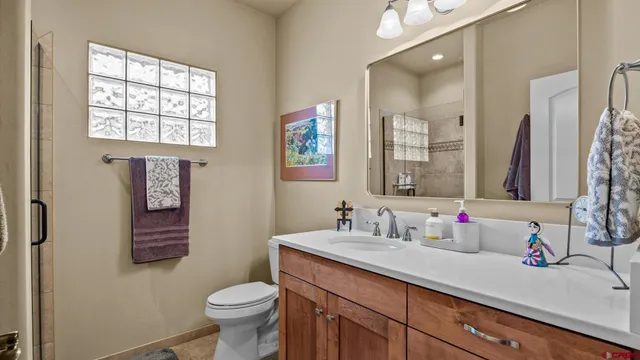 a bathroom with a granite countertop toilet sink and mirror