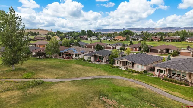 an aerial view of residential houses with outdoor space and swimming pool