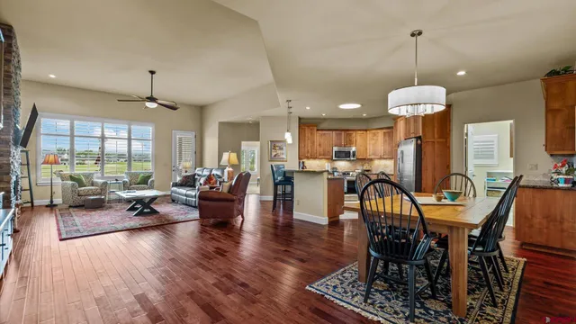 a living room with furniture kitchen view and a chandelier