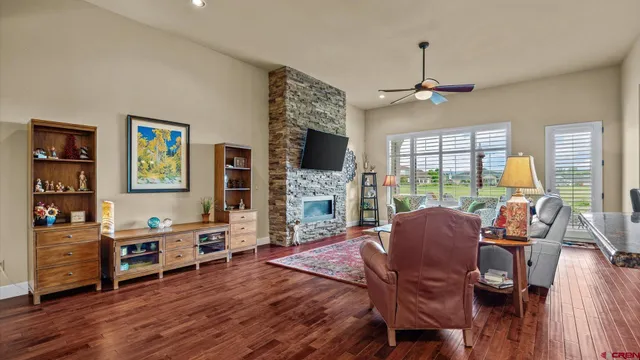 a living room with furniture a flat screen tv and a floor to ceiling window