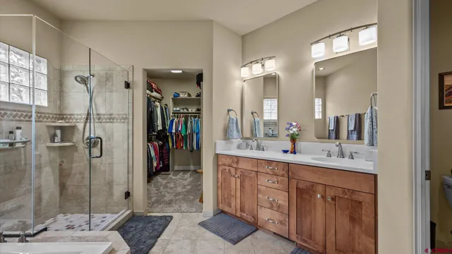 a bathroom with a double vanity sink mirror and shower