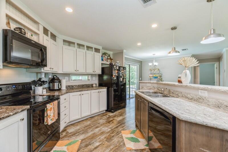 4488 Creek Road Vernon, FL 32462 - Photo 13 of 35 a kitchen with stainless steel appliances granite countertop a sink stove and refrigerator
