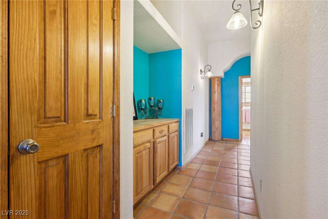 519 North Racetrack Road Henderson, NV 89015 - Photo 39 of 98 Corridor featuring light tile patterned floors, baseboards, visible vents, and arched walkways