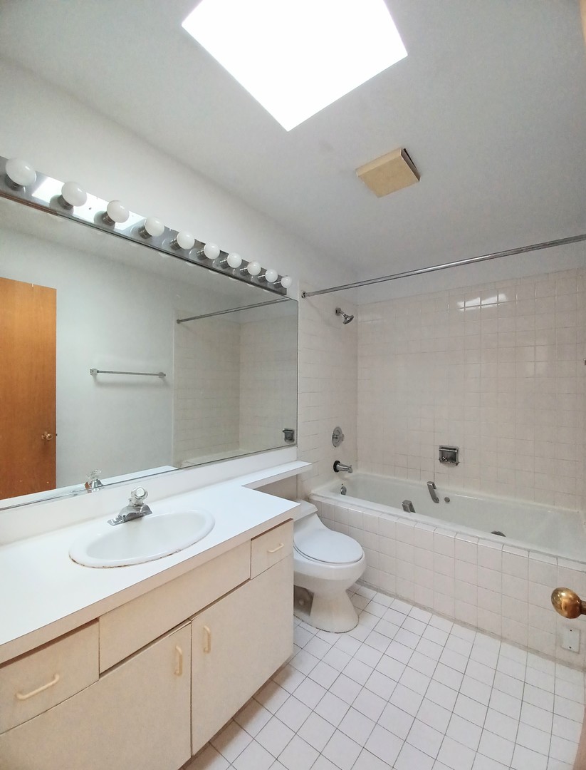 727 South Ashland Avenue, Unit D Chicago, IL 60607 - Photo 18 of 32 a bathroom with a double vanity sink a toilet and a bathtub
