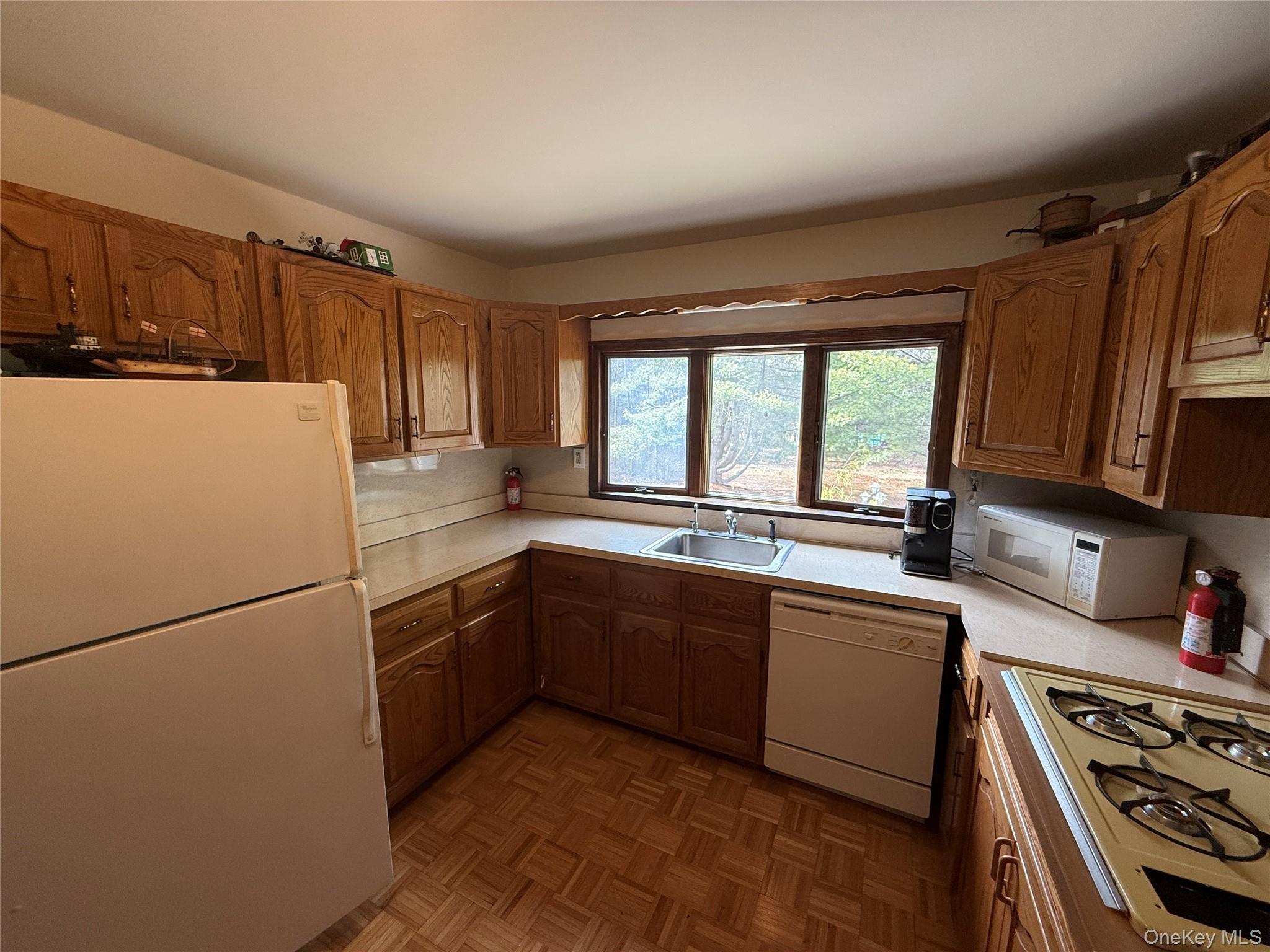 1441 Ulster Heights Road Ellenville, NY 12428 - Photo 17 of 35 a kitchen with sink a refrigerator and wooden cabinets