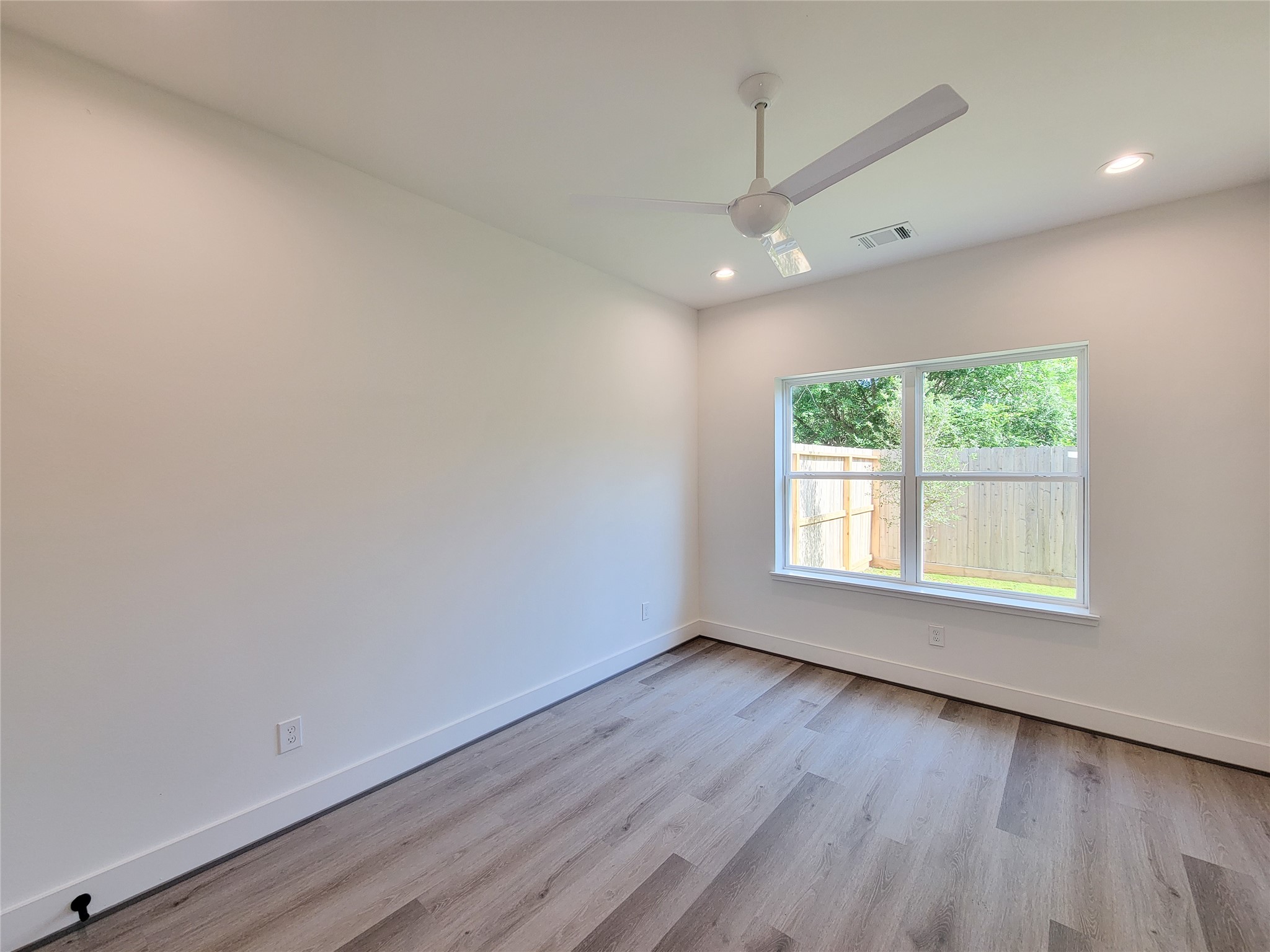 7705 Earl Rudder Way Houston, TX 77055 - Photo 7 of 39 an empty room with wooden floor and windows