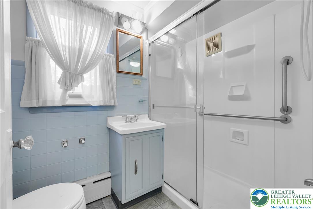 1130 Spring Street Bethlehem, PA 18018 - Photo 27 of 42 a bathroom with a sink a toilet and a mirror