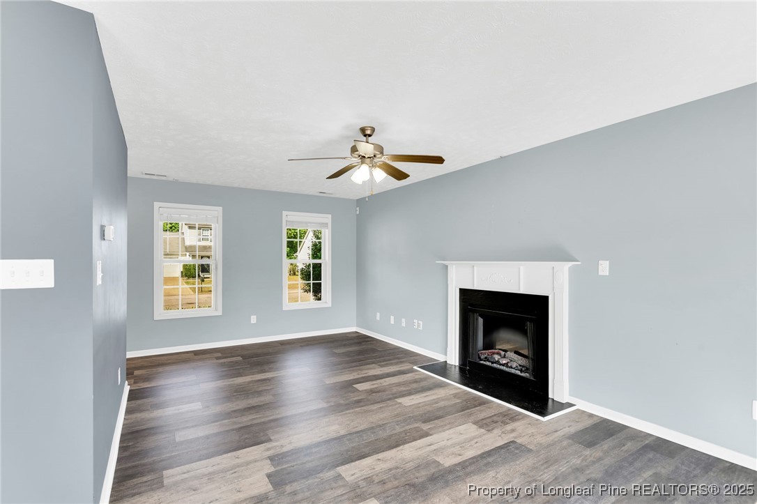 229 Cape Fear Road Raeford, NC 28376 - Photo 14 of 46 a view of an empty room with wooden floor fireplace and a window