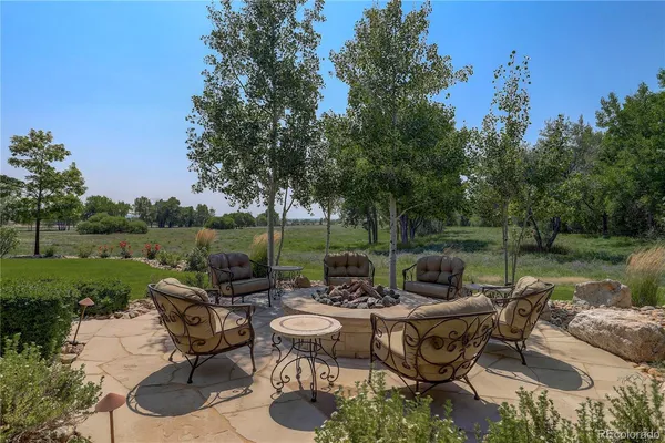 a view of a patio with couches potted plants and a big yard