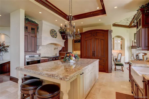 a kitchen with kitchen island granite countertop a stove and a sink