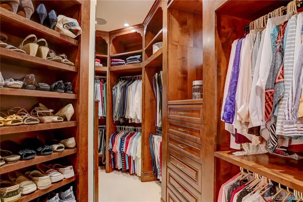 a view of walk in closet with clothes and shoes