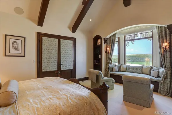 a bedroom with furniture and large windows
