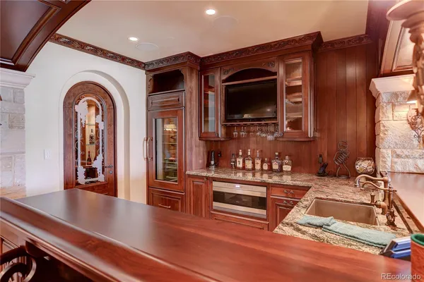 a living room with stainless steel appliances furniture a fireplace and flat screen tv