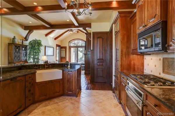 a large kitchen with stainless steel appliances granite countertop a stove and a sink
