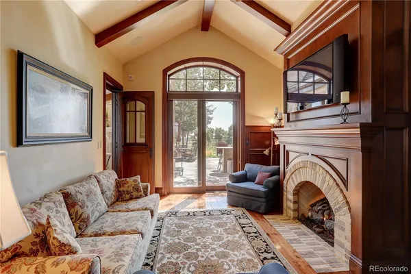 a living room with furniture a large window and a fireplace