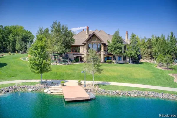 a view of a house with a big yard potted plants and large tree