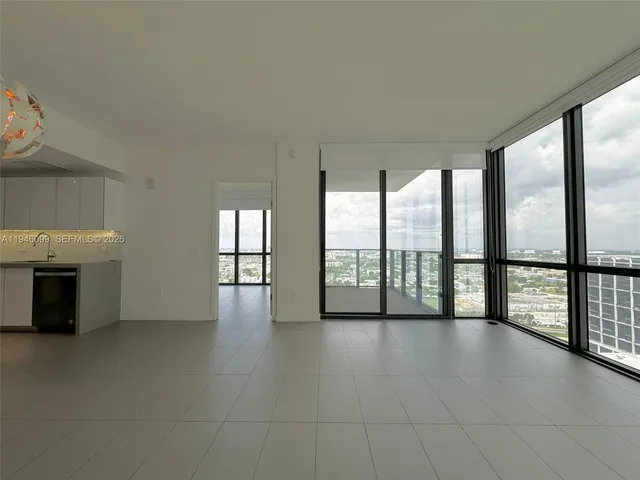 a view of an empty room with a fireplace and a window