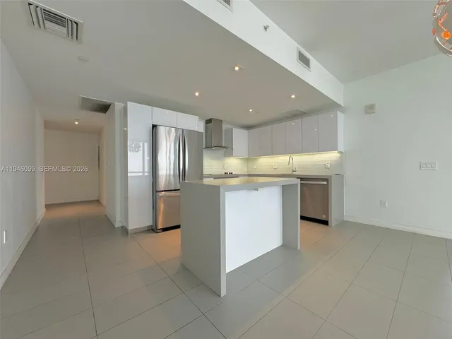 a kitchen with stainless steel appliances a refrigerator sink and microwave