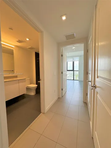 a view of a hallway with closet and a living room