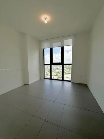 an empty room with windows and brick walls