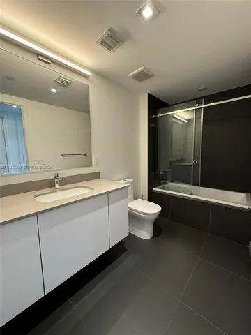 a bathroom with a double vanity sink toilet and shower