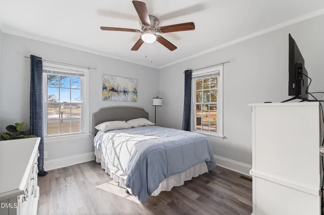 a bedroom with a bed wooden floor and window