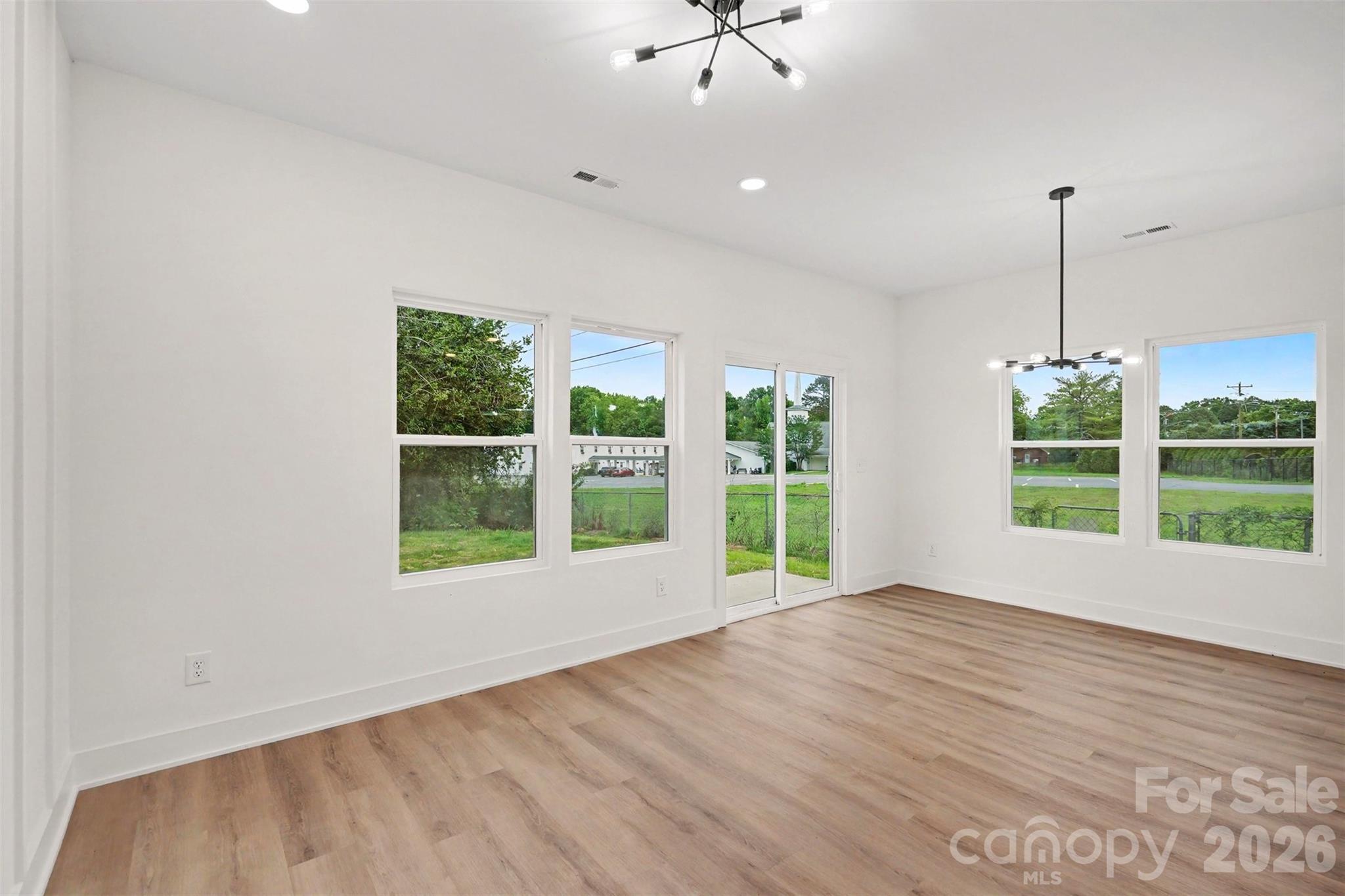 7521 Lawyers Road Charlotte, NC 28227 - Photo 12 of 35 a view of an empty room with a window and wooden floor