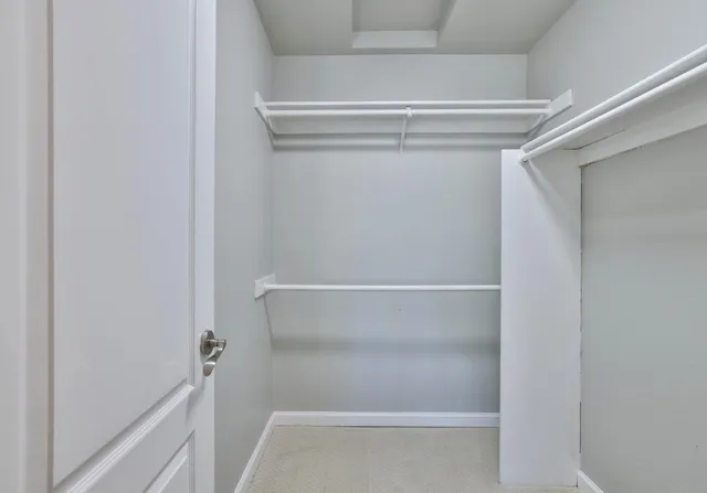 a view of walk in closet with empty racks