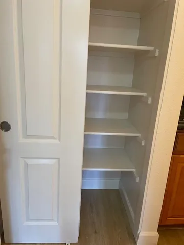 a view of walk in closet with empty racks