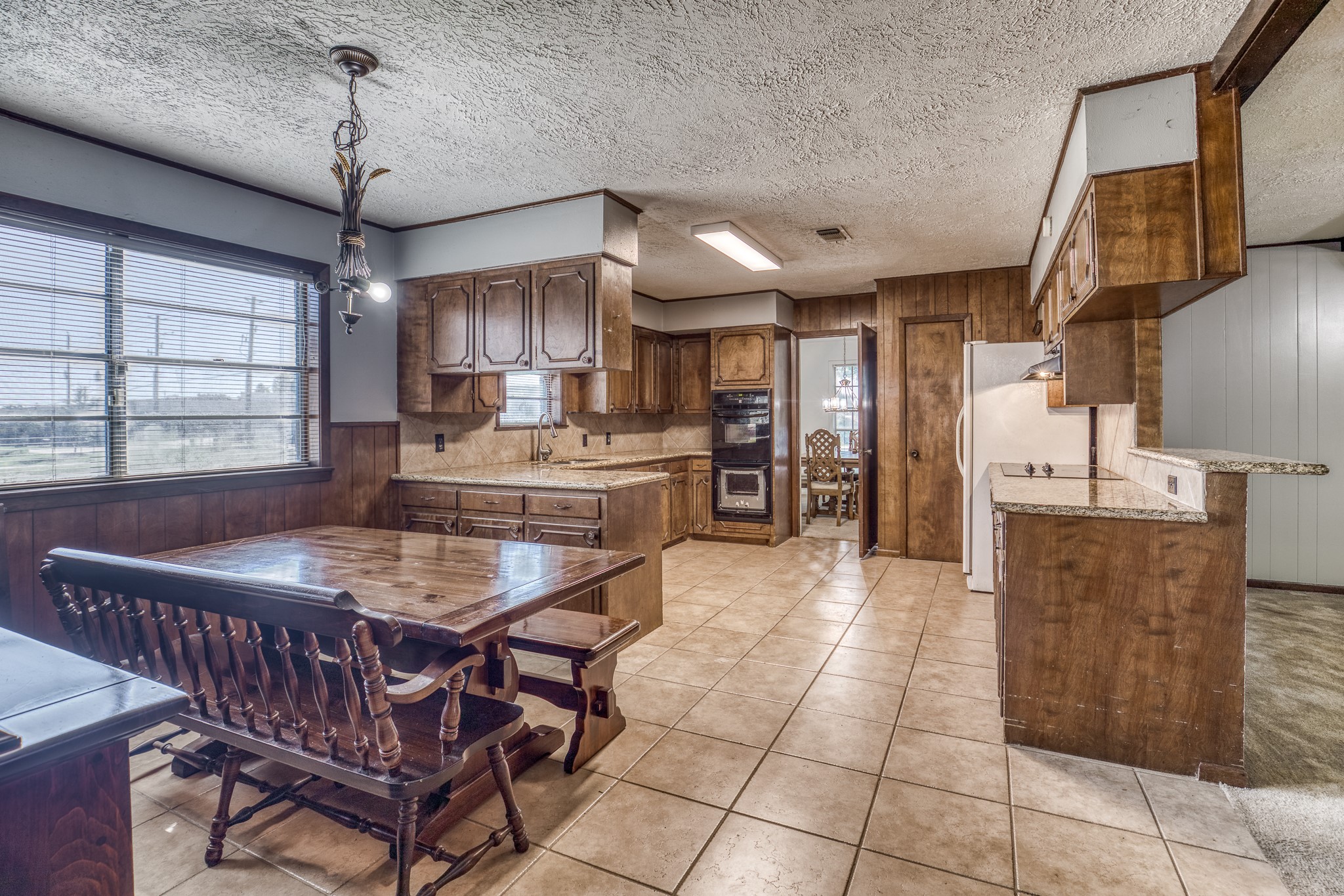 1687 Eagle Lake Road Sealy, TX 77474 - Photo 13 of 27 a kitchen with stainless steel appliances kitchen island granite countertop a table chairs and a refrigerator