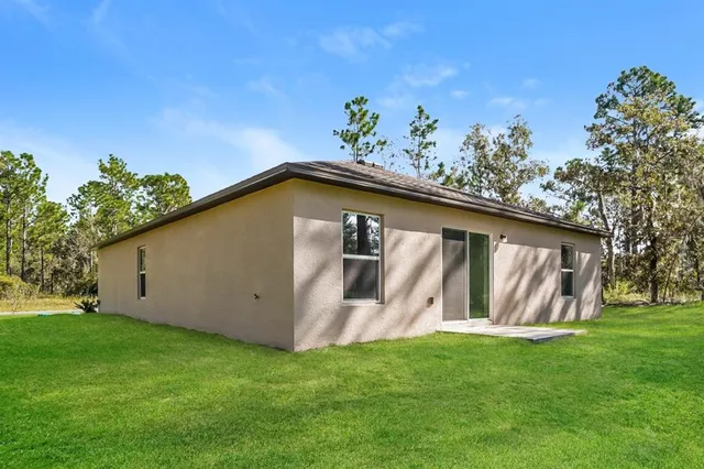 a view of a backyard with potted plants and large tree