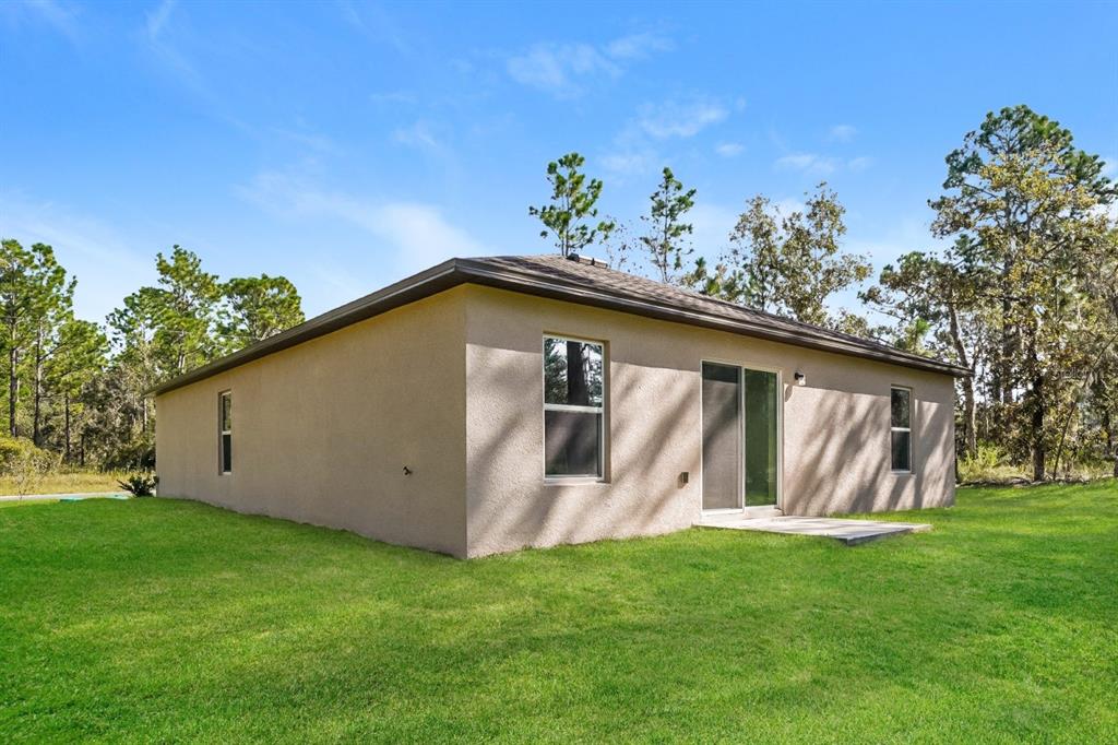 2660 West Bravura Drive Citrus Springs, FL 34433 - Photo 13 of 14 a view of a backyard with potted plants and large tree