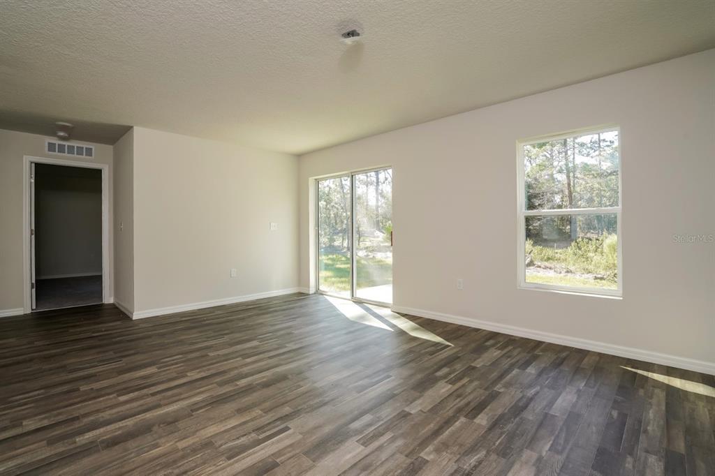 2660 West Bravura Drive Citrus Springs, FL 34433 - Photo 3 of 14 a view of an empty room with wooden floor and a window