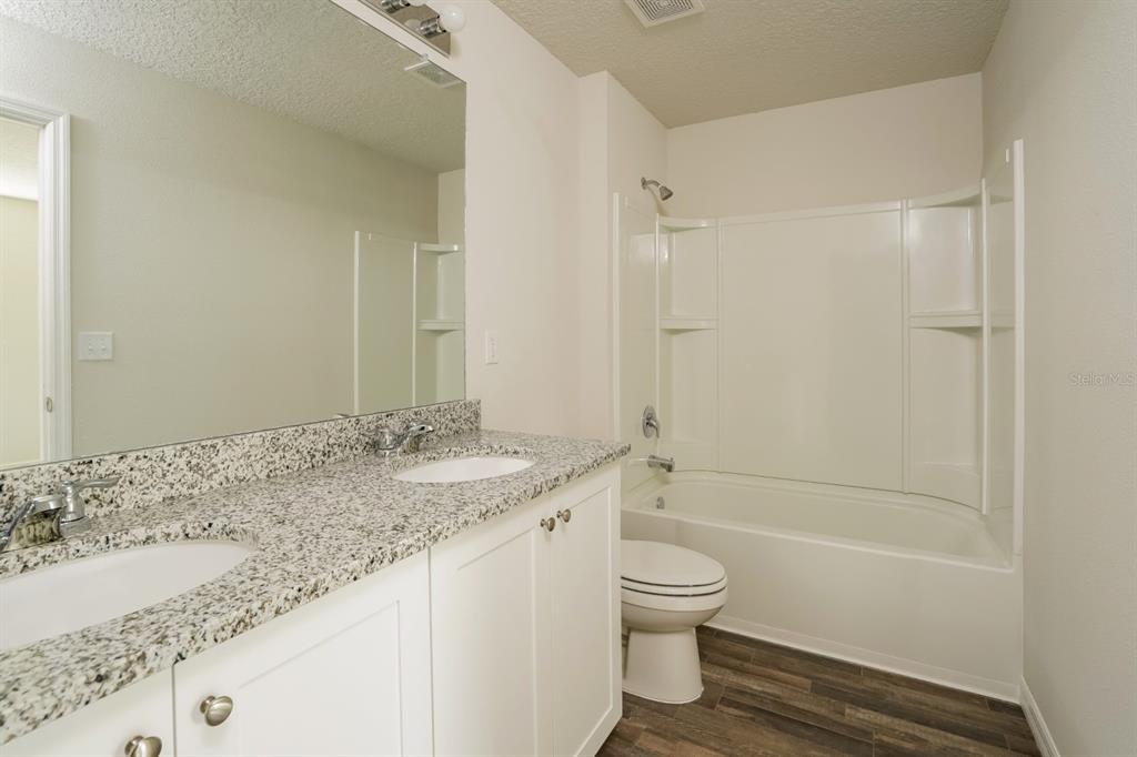 2660 West Bravura Drive Citrus Springs, FL 34433 - Photo 10 of 14 a bathroom with a granite countertop sink a toilet and shower
