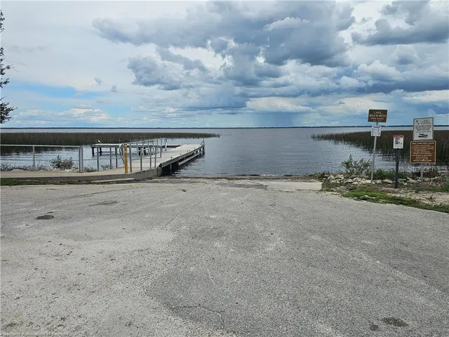 a view of a dry yard with wooden fence