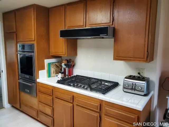 5984 Palencia Drive Riverside, CA 92509 - Photo 7 of 16 a kitchen with stainless steel appliances granite countertop a refrigerator a stove and a microwave
