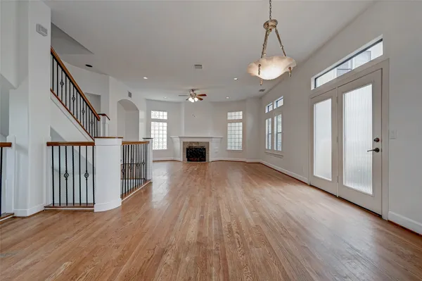 a view of a hallway with wooden floor and a kitchen