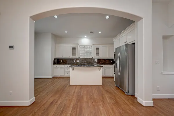 a kitchen with a refrigerator and white cabinets
