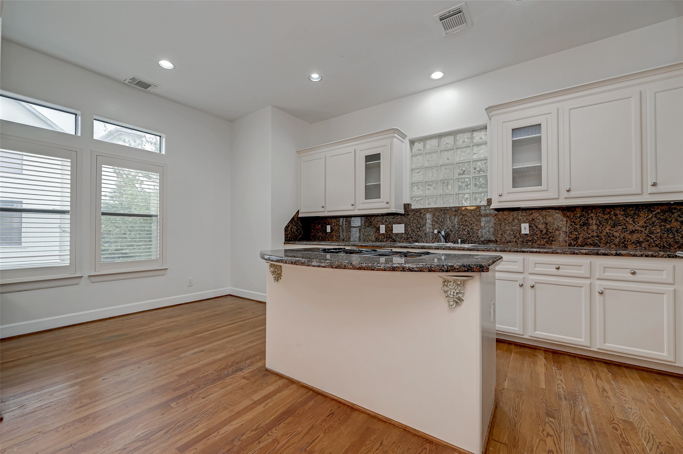 5410 Rose Street Houston, TX 77007 - Photo 18 of 41 a kitchen with granite countertop white cabinets sink and wooden floor