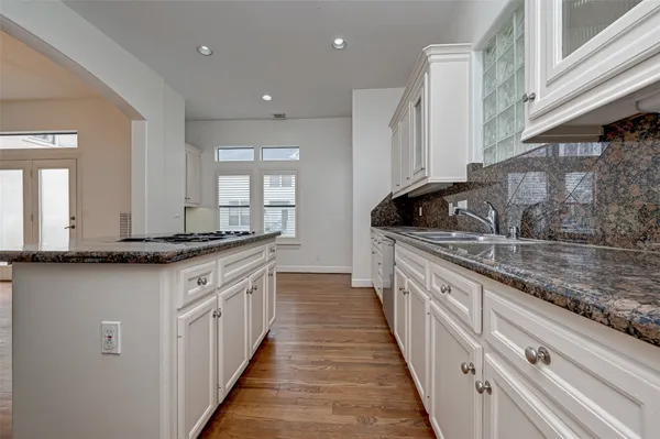a kitchen with granite countertop a sink and a stove
