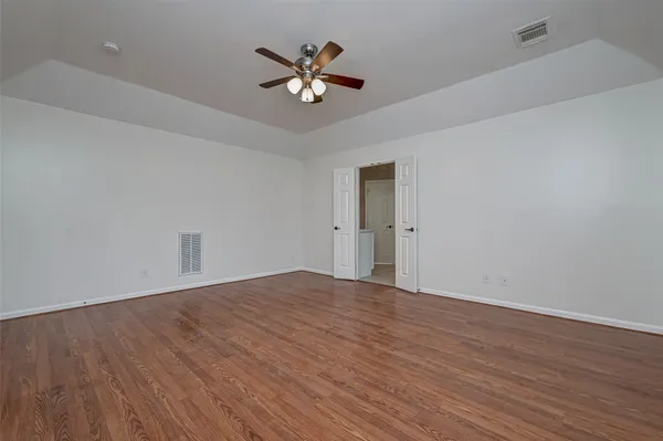 a view of an empty room with wooden floor