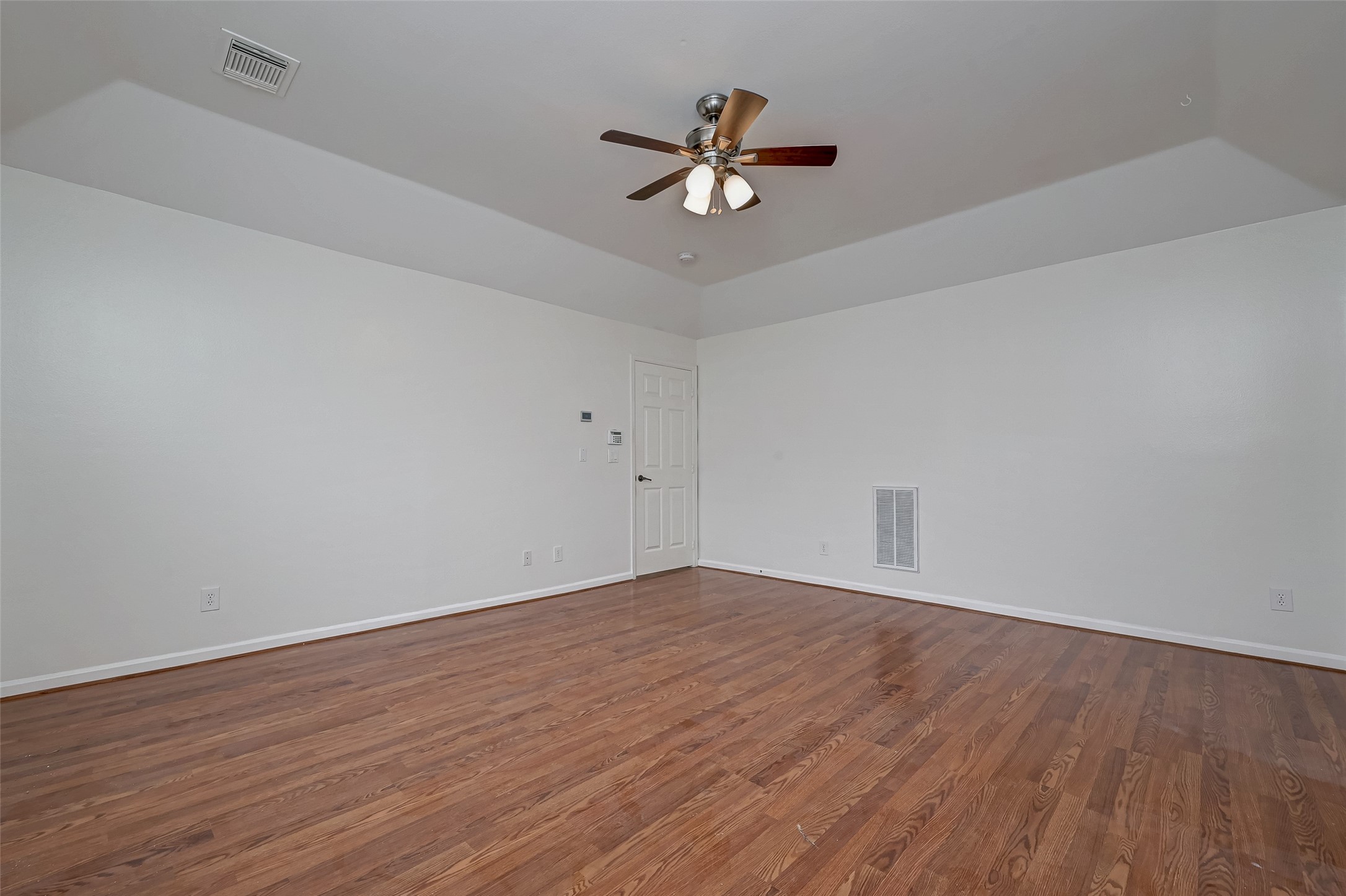 5410 Rose Street Houston, TX 77007 - Photo 30 of 41 a view of an empty room with wooden floor and a ceiling fan