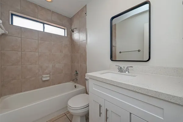 a bathroom with a toilet a sink a mirror and bathtub