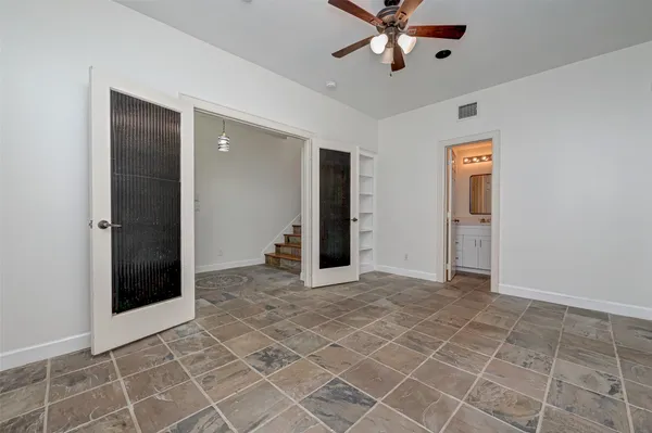 an empty room with windows and fan