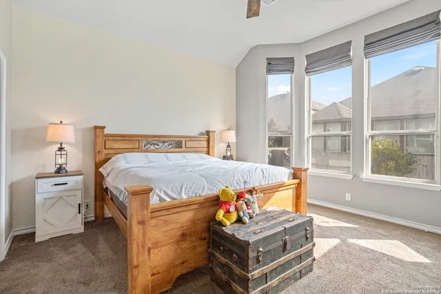 a bedroom with a bed and large windows